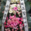 Standing funeral wreath with pink and white flowers and Korean condolence ribbons
