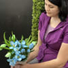 Woman holding a bouquet of blue flowers and green tulips