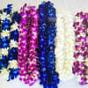Colorful orchid leis arranged in rows on a white background