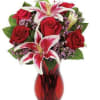 Red roses and pink lilies in a red glass vase
