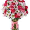 Pink and white bouquet of roses, carnations, and daisies in a glass vase