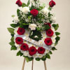 Red roses and white flowers arranged on a standing easel with a ribbon