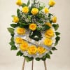 Yellow rose wreath on an easel with white flowers and a ribbon