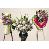 Three large floral standing arrangements in white, pink, and yellow