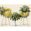Three floral funeral tributes with yellow and white flowers on stands