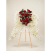 Red roses and white chrysanthemum funeral spray on a wooden easel