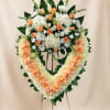 Heart-shaped floral wreath on an easel with peach roses and white flowers