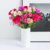 Bouquet of pink and white flowers in a tall white vase