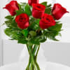 Medium bouquet of red roses arranged with foliage in a clear glass vase