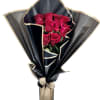 Bouquet of red roses wrapped in black paper with a beige ribbon bow