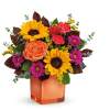 Colorful bouquet with sunflowers, roses, and daisies in an orange vase