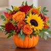 Fall bouquet in a pumpkin container with roses and a sunflower