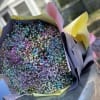 Bouquet of tiny multicolored flowers wrapped in pastel paper