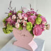 Pink rose bouquet in a heart-shaped box with green accents