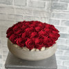 Round arrangement of red roses in a low gray bowl
