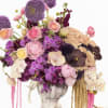 Lavender and pink floral arrangement in a pedestal vase