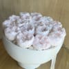 Round box of pale pink peonies with a ribbon tag