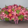 Pink floral arrangement with roses and peonies in a low bowl