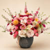 Pink and cream rose bouquet in a dark vase