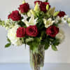 Red roses and white lilies arranged in a clear glass vase