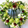 Heart-shaped floral wreath with red and white roses and green hydrangeas