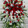Large standing floral spray with red roses, white lilies, and white orchids