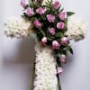 Cross-shaped floral tribute with pink roses and white chrysanthemums