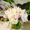 Soft pink and white bouquet in a green glass vase