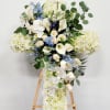 White floral standing spray with orchids, roses, and chrysanthemums