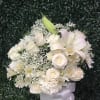 White rose and lily bouquet with baby's breath in a white vase