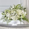 White floral arrangement in a white pedestal vase