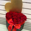 Heart-shaped box filled with red roses and tied with a red ribbon