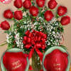 Red roses with baby’s breath in a glass vase and red ribbon