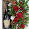 Gift box with a champagne bottle and red rose arrangement