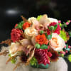 Mixed bouquet with roses, orchids, and chrysanthemums in a low container
