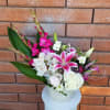 Pink lilies and white roses in a decorative white vase