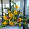 Basket arrangement with yellow sunflowers and mixed greenery