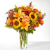 Bouquet of orange and yellow flowers in a clear glass vase