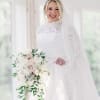 Bride in a white lace gown holding a cascading bouquet of white and blush flowers