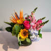 Mixed bouquet in a round vase with sunflower, roses, hydrangea, and snapdragons