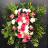 Pink and white rose funeral spray with lush greenery