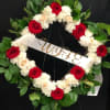 Heart-shaped floral wreath with red and white roses and a "WIFE" ribbon