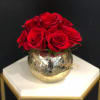 Red roses arranged in a gold mirrored vase