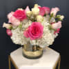 Pink and white roses arranged in a glass vase
