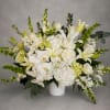 An abundant arrangement of white orchids, lilies, roses, hydrangea, and premium blooms