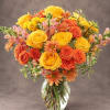 Yellow and orange roses with daisies in a clear glass vase