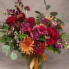 Large bouquet of red roses and mixed flowers in a glass vase