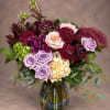 Bouquet of purple and burgundy flowers in a glass vase