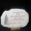 Memorial stone plaque with engraved trees and text on a stand