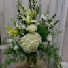 White floral arrangement with lilies, roses, and hydrangea in a glass vase